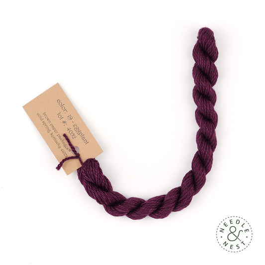 Silk & Ivory Eggplant Thread on a White Background